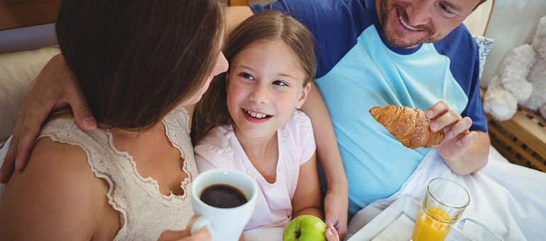 Familie frühstückt im Bett beim Bed & Breakfast in Dover